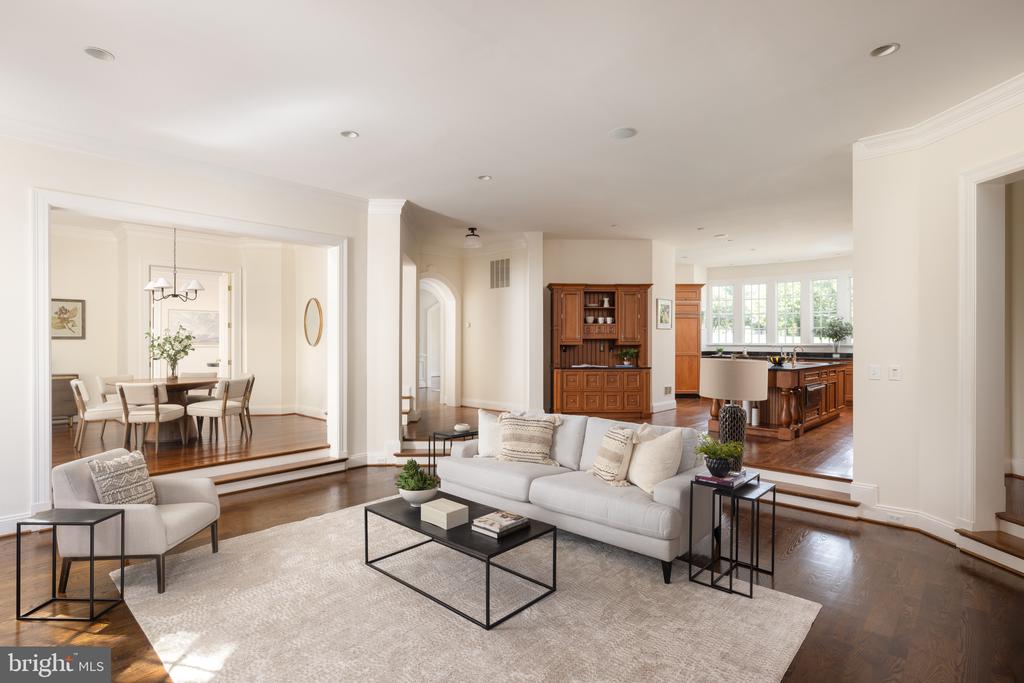 Living room with a white sofa and rug, open to the dining room and kitchen.