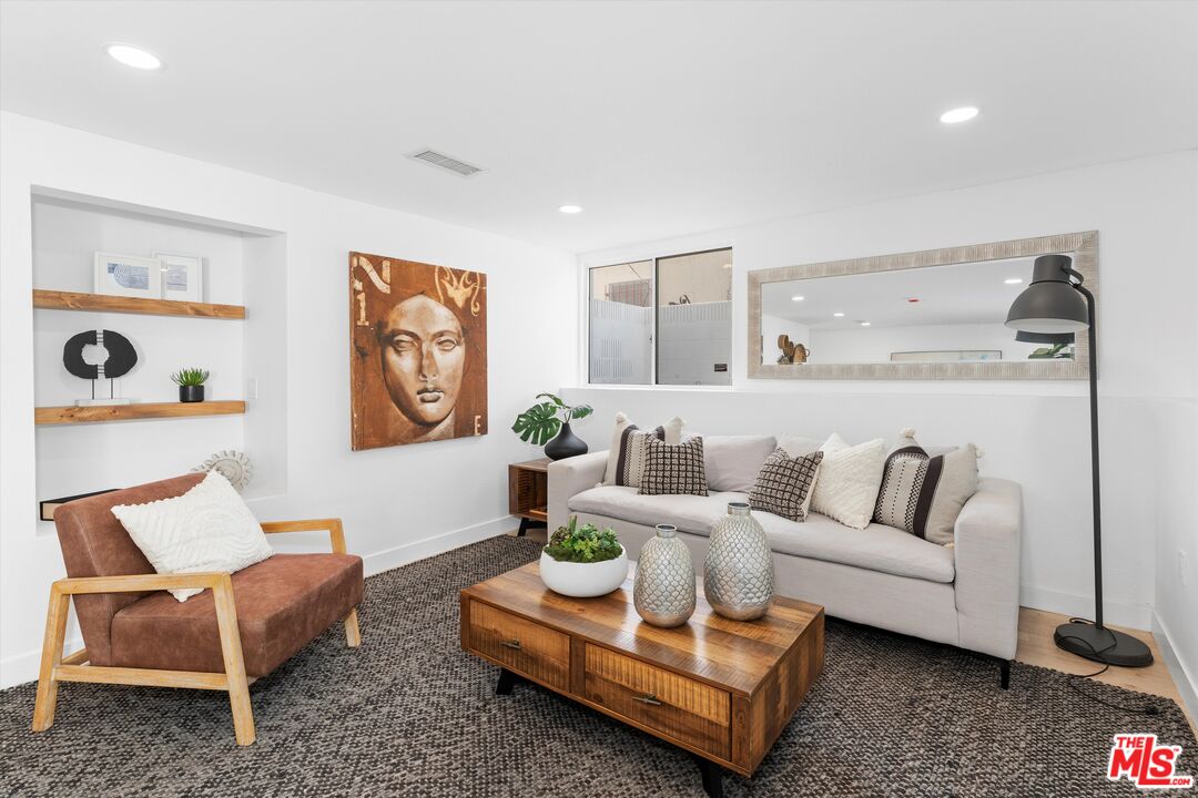 Staged living room with a light sofa, rust-colored armchair, and wood coffee table.