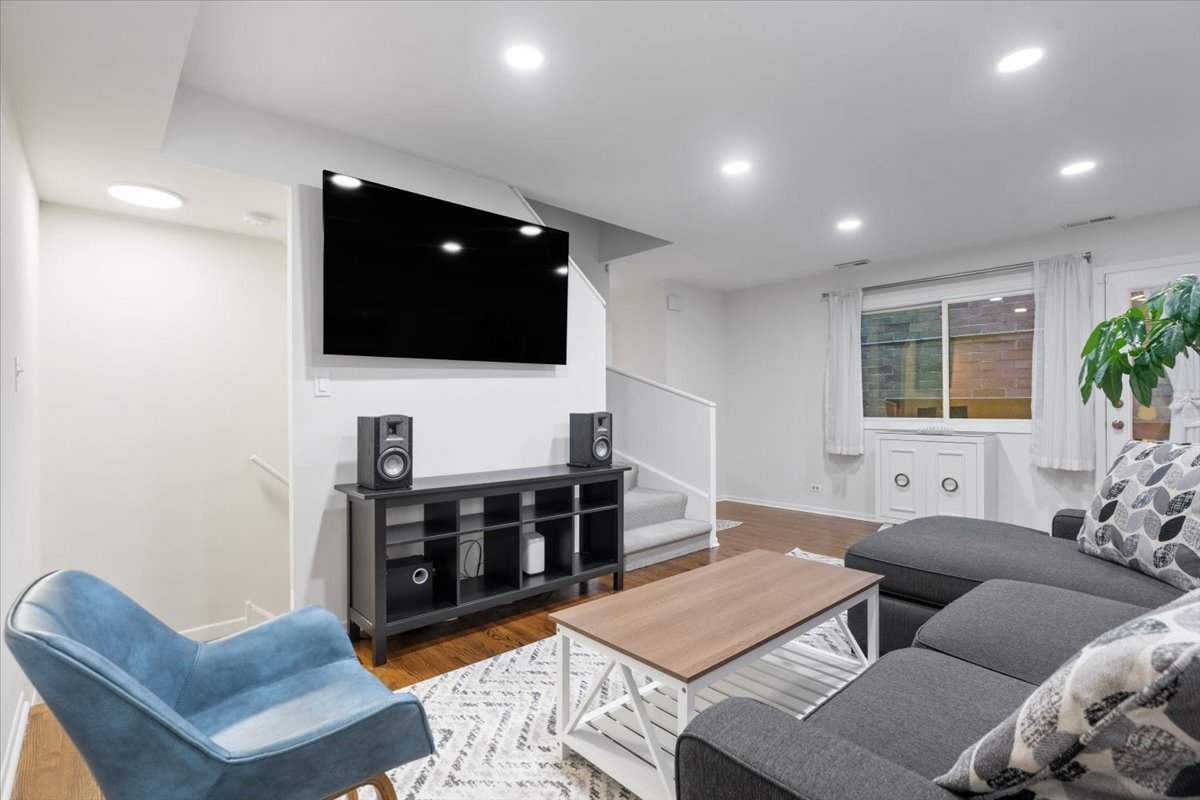 Living room with gray sectional, blue accent chair, and large wall-mounted television.