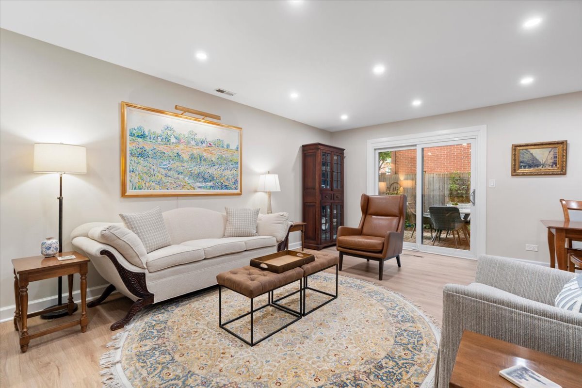 Living room with a cream sofa, patterned rug, and sliding glass doors to a patio.