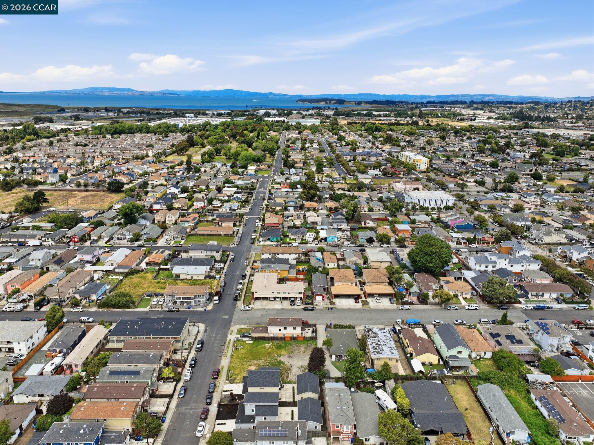 Aerial view of a Richmond neighborhood with the bay and distant hills beyond.