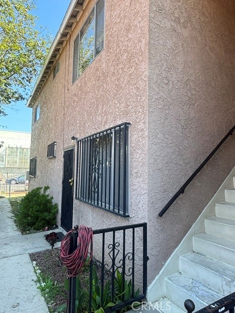 Exterior of 726 E 31st with barred windows and an outdoor staircase.