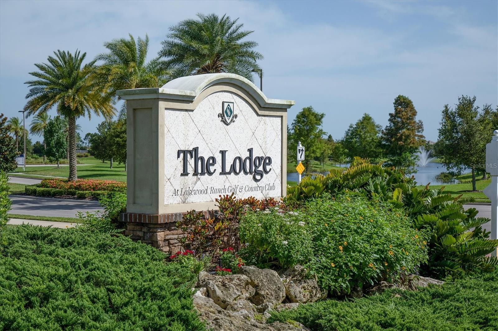 The Lodge entrance sign at Lakewood Ranch Golf & Country Club, surrounded by palms and landscaped grounds.