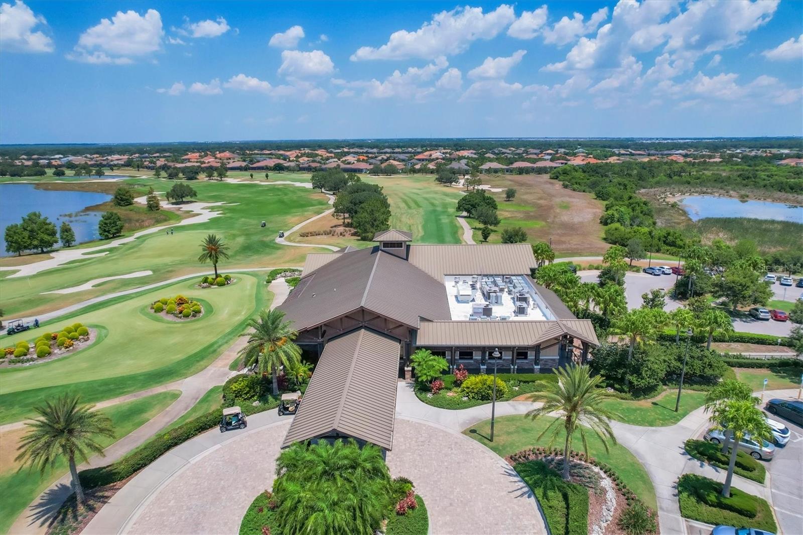 Golf course clubhouse and landscaped grounds, with fairways and ponds stretching into the surrounding neighborhood.