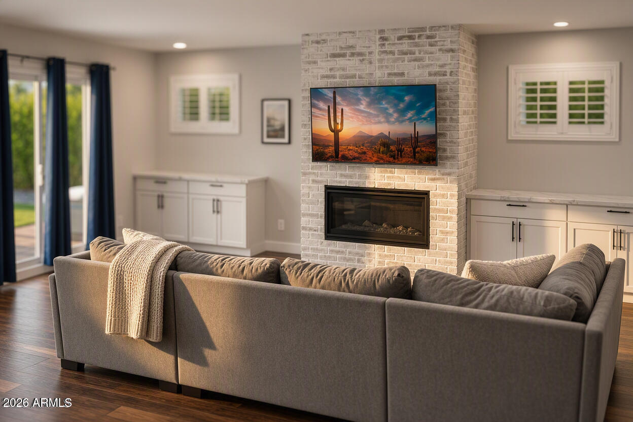 Living room with a gray sectional, brick fireplace, and built-in white cabinets.