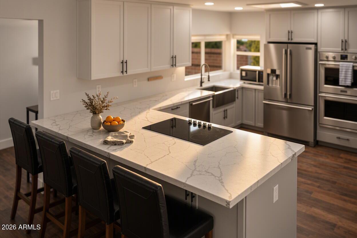 Modern kitchen with a large veined stone island, cooktop, seating, and stainless steel appliances.