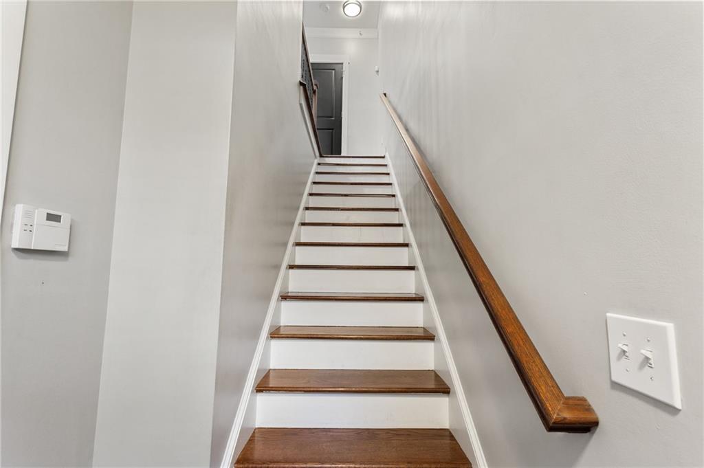 Interior staircase with dark wood treads, white risers, and a matching wooden handrail.
