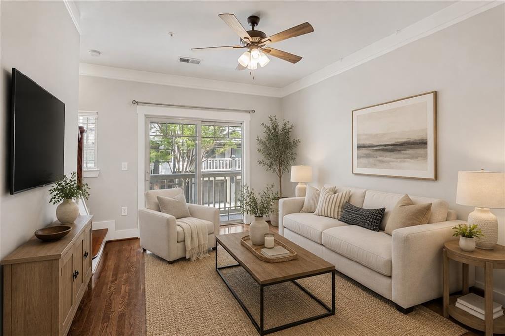 Living room with cream seating, hardwood floors, and sliding glass doors to a balcony.