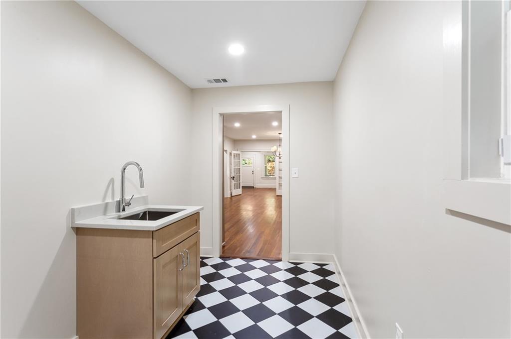 Utility room with a wood sink cabinet and black-and-white checkerboard floor.