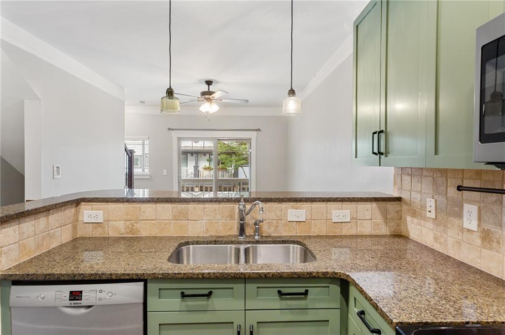Kitchen with sage-green cabinets, granite counters, a double-basin sink, and a Bosch dishwasher.
