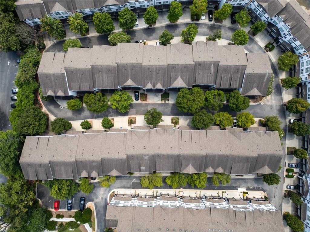 Aerial view of attached homes in a residential complex, with tree-lined driveways between the buildings.