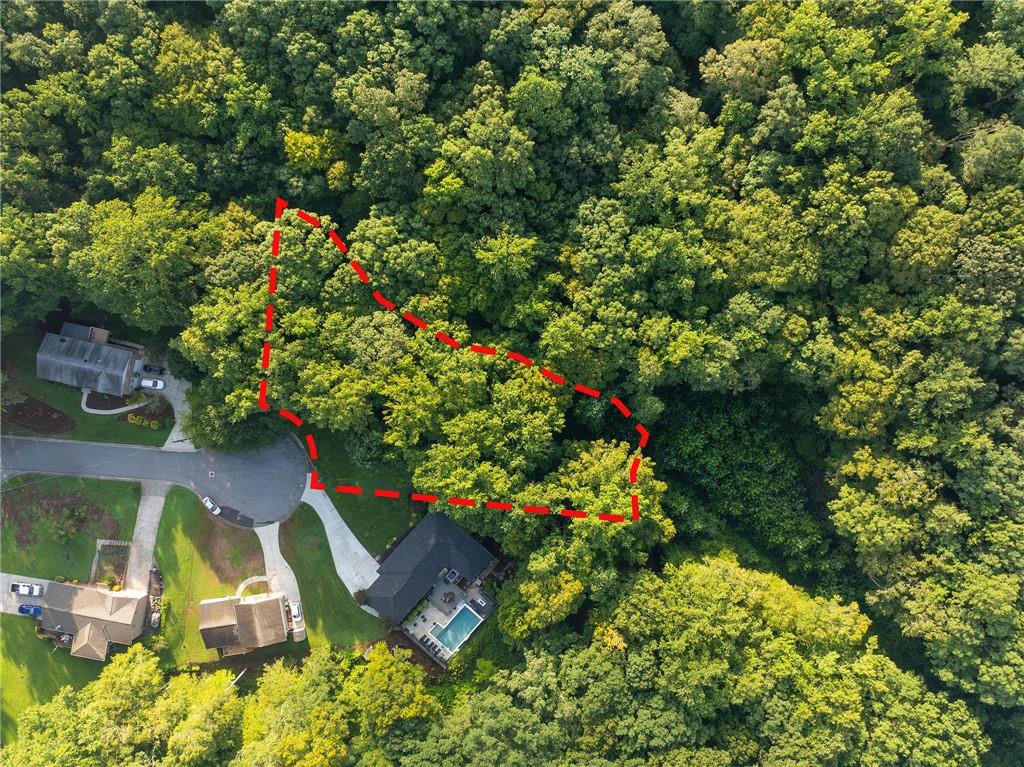 Wooded Smyrna lot outlined in red beside a cul-de-sac and neighboring homes.