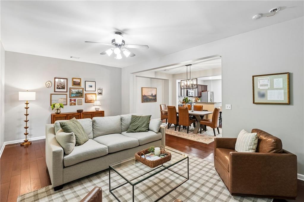 Living room with a gray sectional, leather armchair, and open dining area.