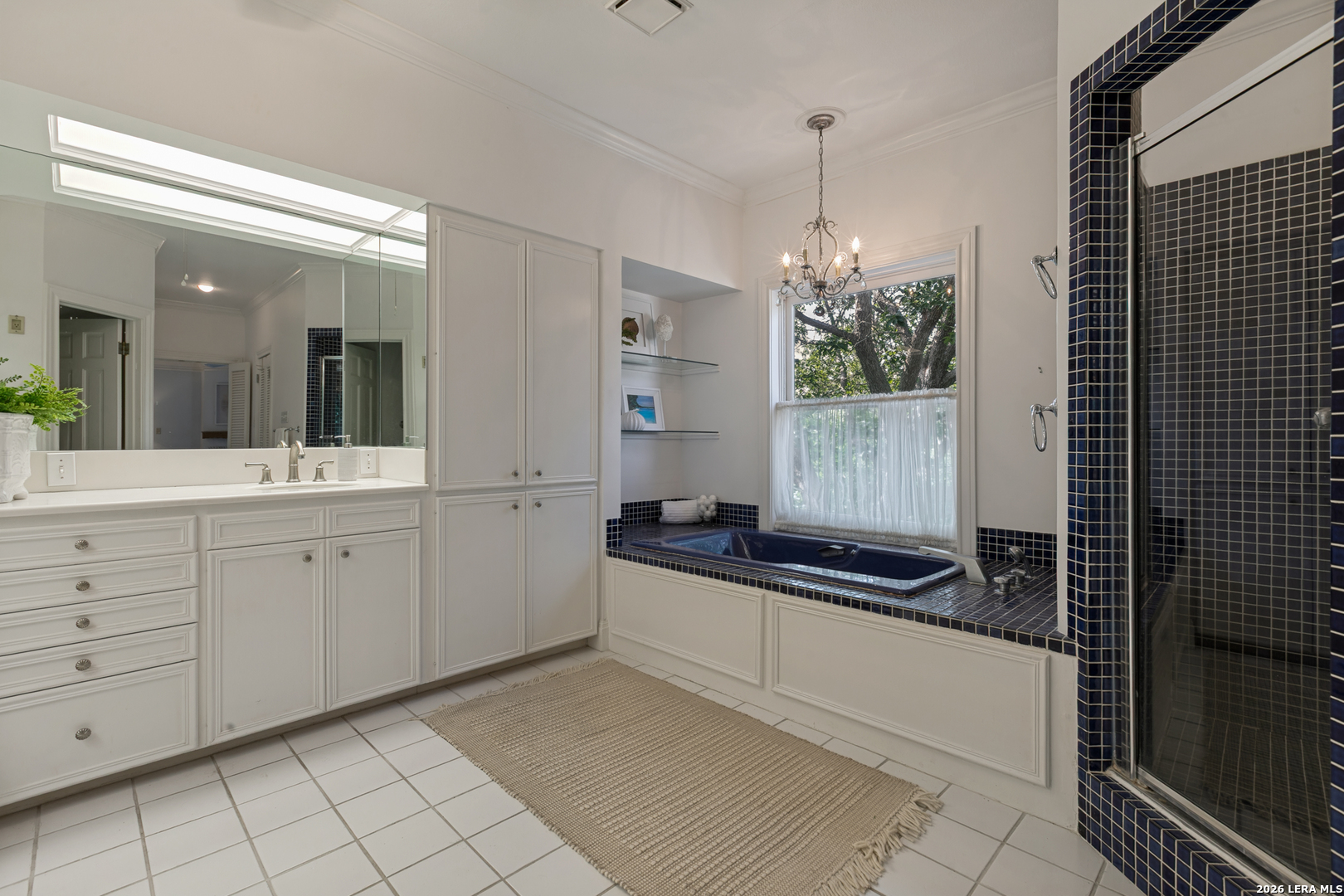 Spacious primary bath in a Terrell Hills home with dual vanities, a soaking tub, and natural light.