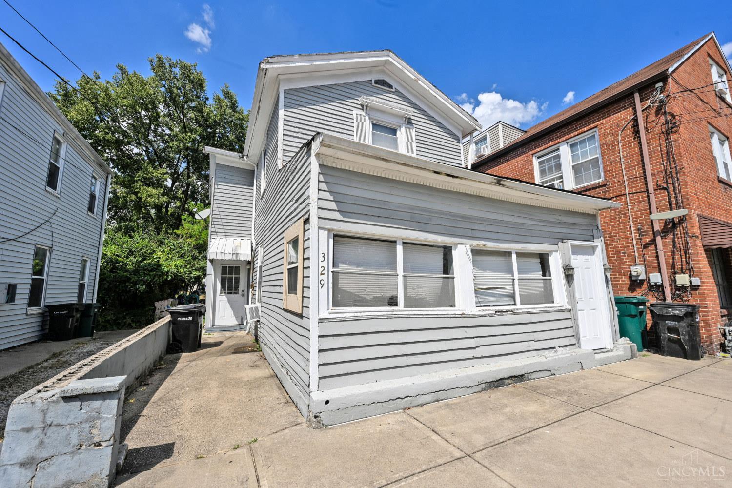 Gray two-story house with white trim and a front extension, numbered 329.