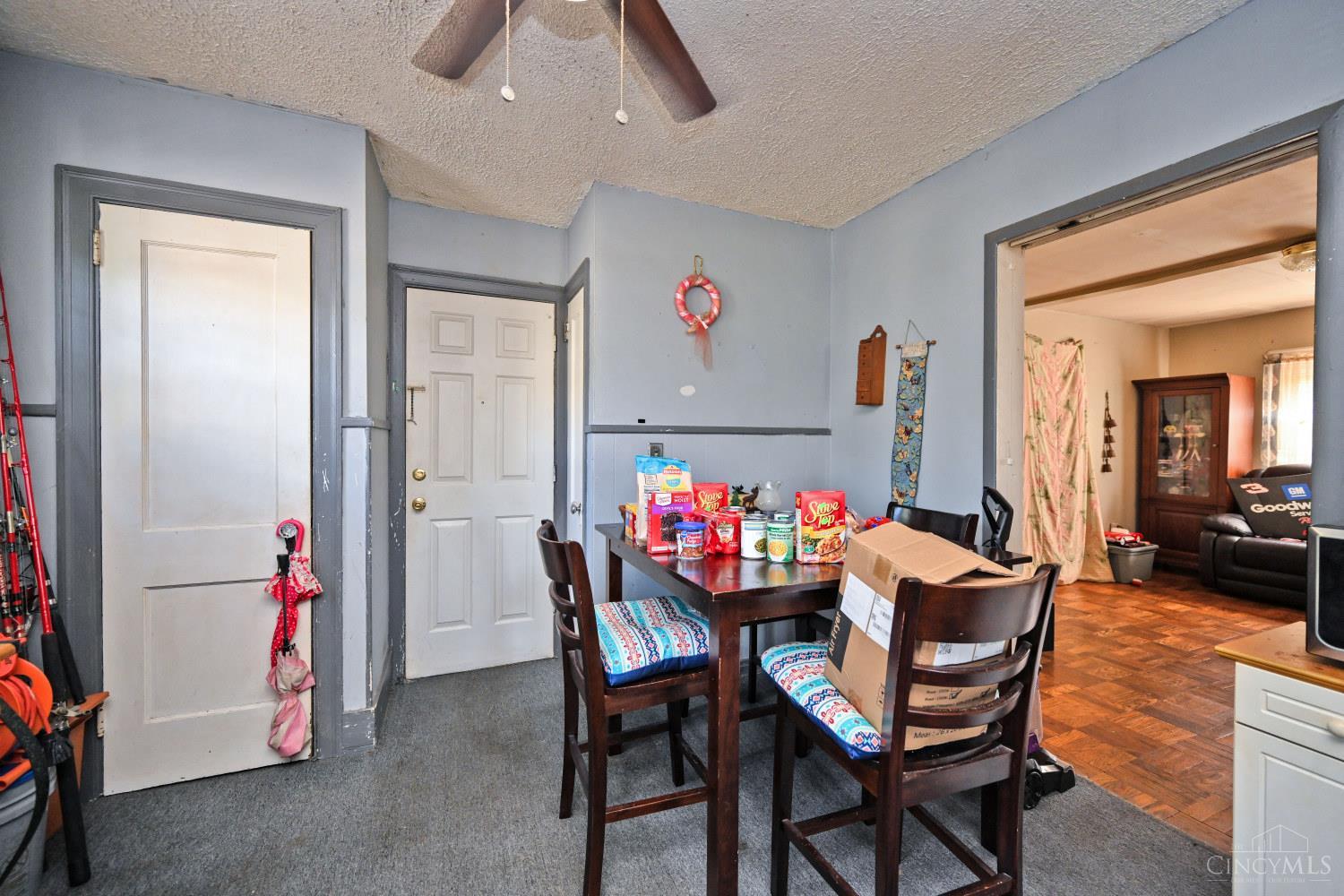 Dining area with a dark wood table and chairs beside an open doorway to the living room.