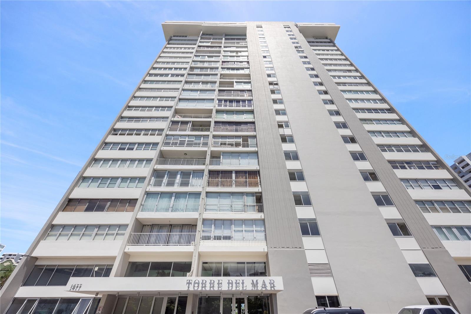 Torre del Mar high-rise with rows of balconies, photographed from below at its 1477 entrance.