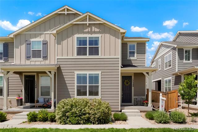 Attached two-story homes with gray siding, covered porches, and landscaped front yards.
