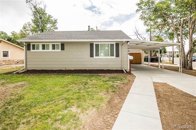 Gray single-story house with a covered carport, concrete driveway, and front lawn.