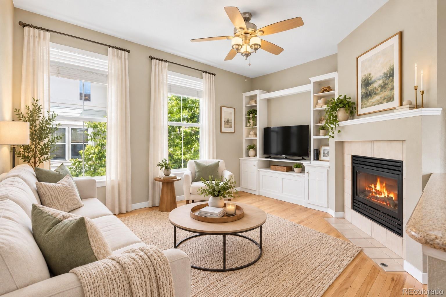 Living room with a white sectional, built-in TV shelves, and a lit fireplace.