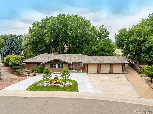 Single-story brick ranch home with a three-car garage and landscaped front yard.