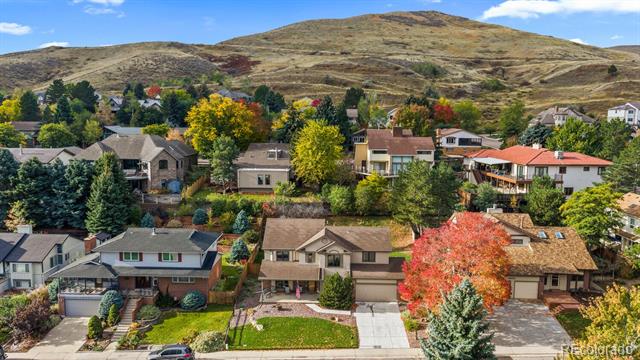 Aerial view of homes with colorful autumn trees and a mountain ridge beyond.