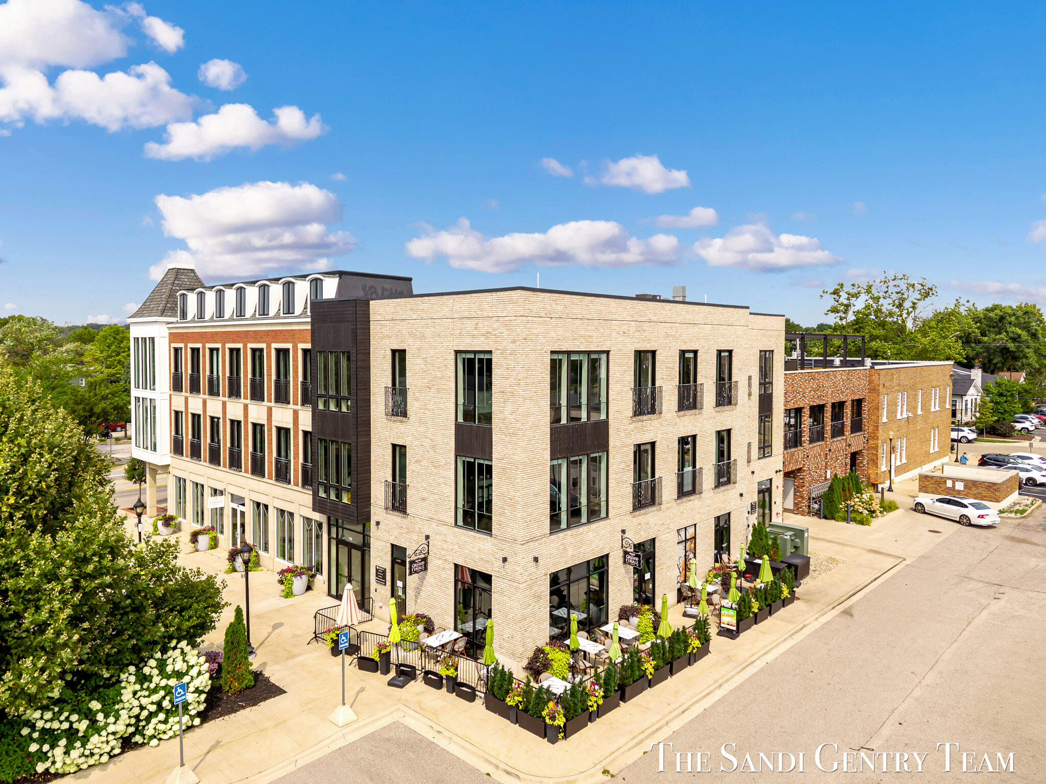 Modern brick commercial building with a flower-lined outdoor dining patio.