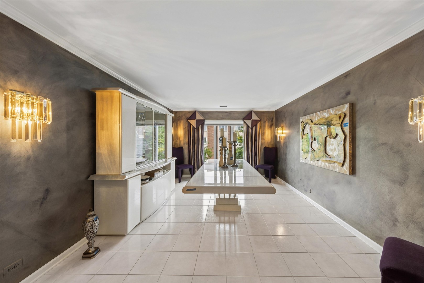 Dining room with a long glossy table, gray walls, and white tile flooring.