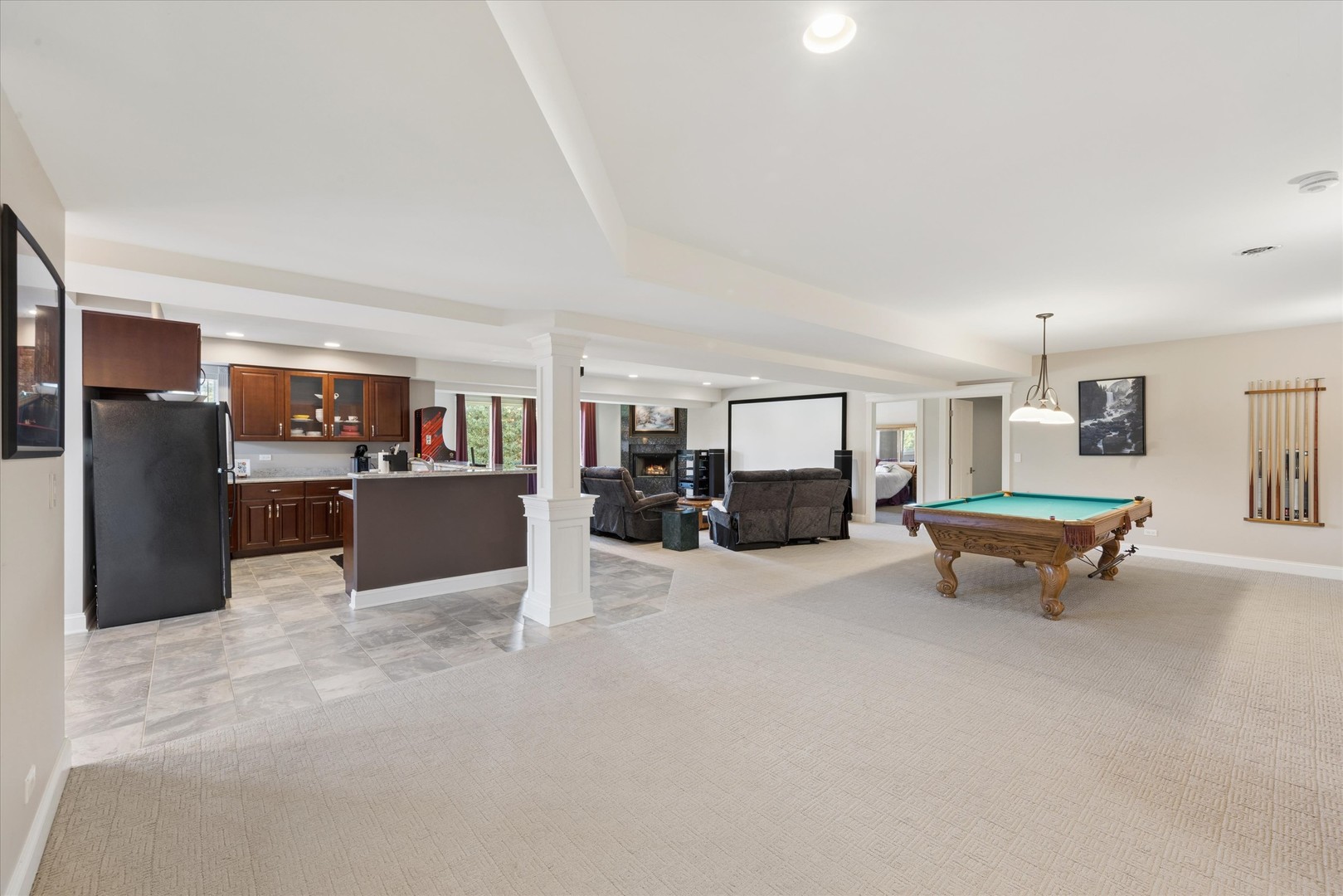 Open recreation room with a kitchen, home theater seating, and billiards table.