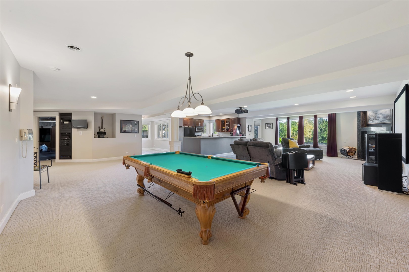 Recreation room with a pool table, television seating area, and kitchen bar.