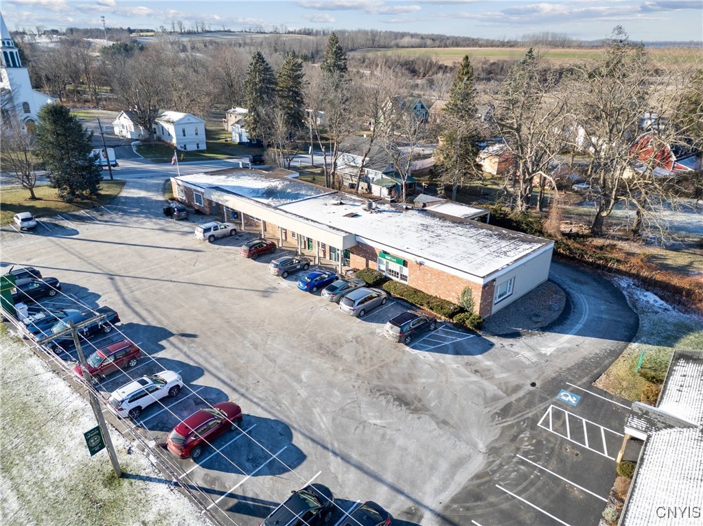 Aerial view of a single-story brick commercial building and its large parking lot.