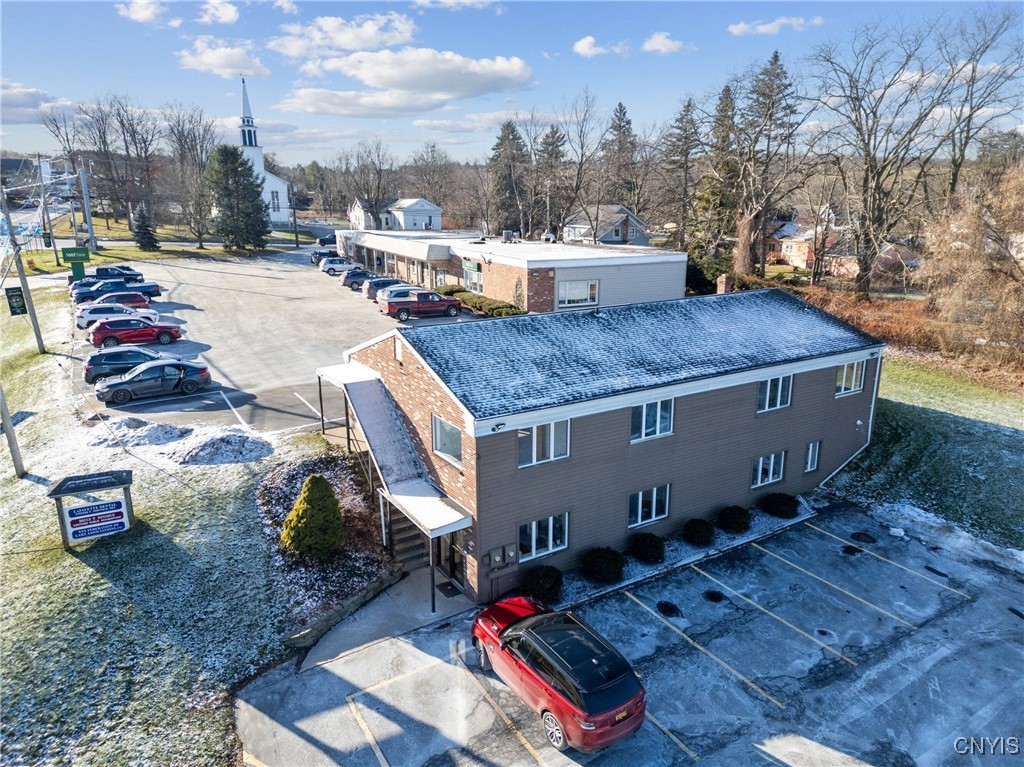 Snow-dusted commercial building and parking lot, viewed from above.