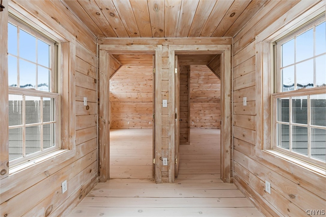 Wood-paneled interior with two open doorways to adjoining rooms and windows on both sides.