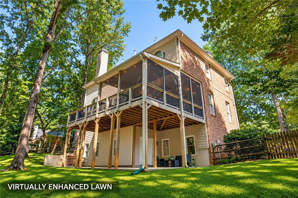 Two-story house with a raised screened deck and brick facade, surrounded by trees and a green lawn.