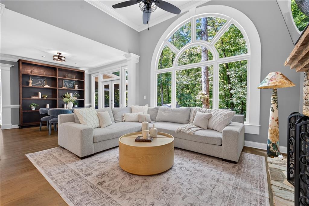 Living room with a large arched window, sectional sofa, built-in bookcase, and fireplace.