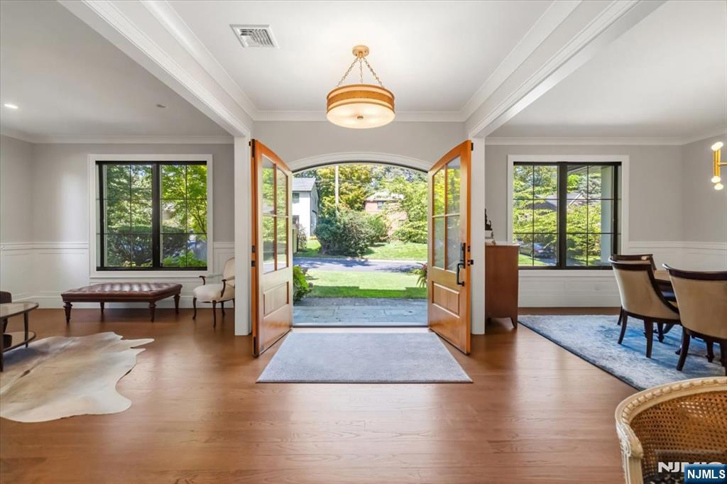 Front entry room with open double doors leading to a stone path and lawn.
