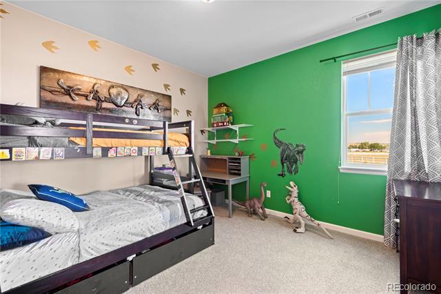 Bedroom with a bunk bed, dinosaur decorations, and a bright green accent wall.