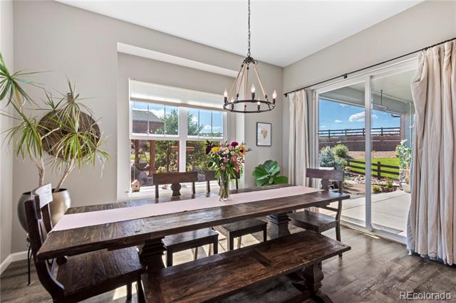 Dining room with a rustic wood table, chandelier, and sliding glass doors to a patio.