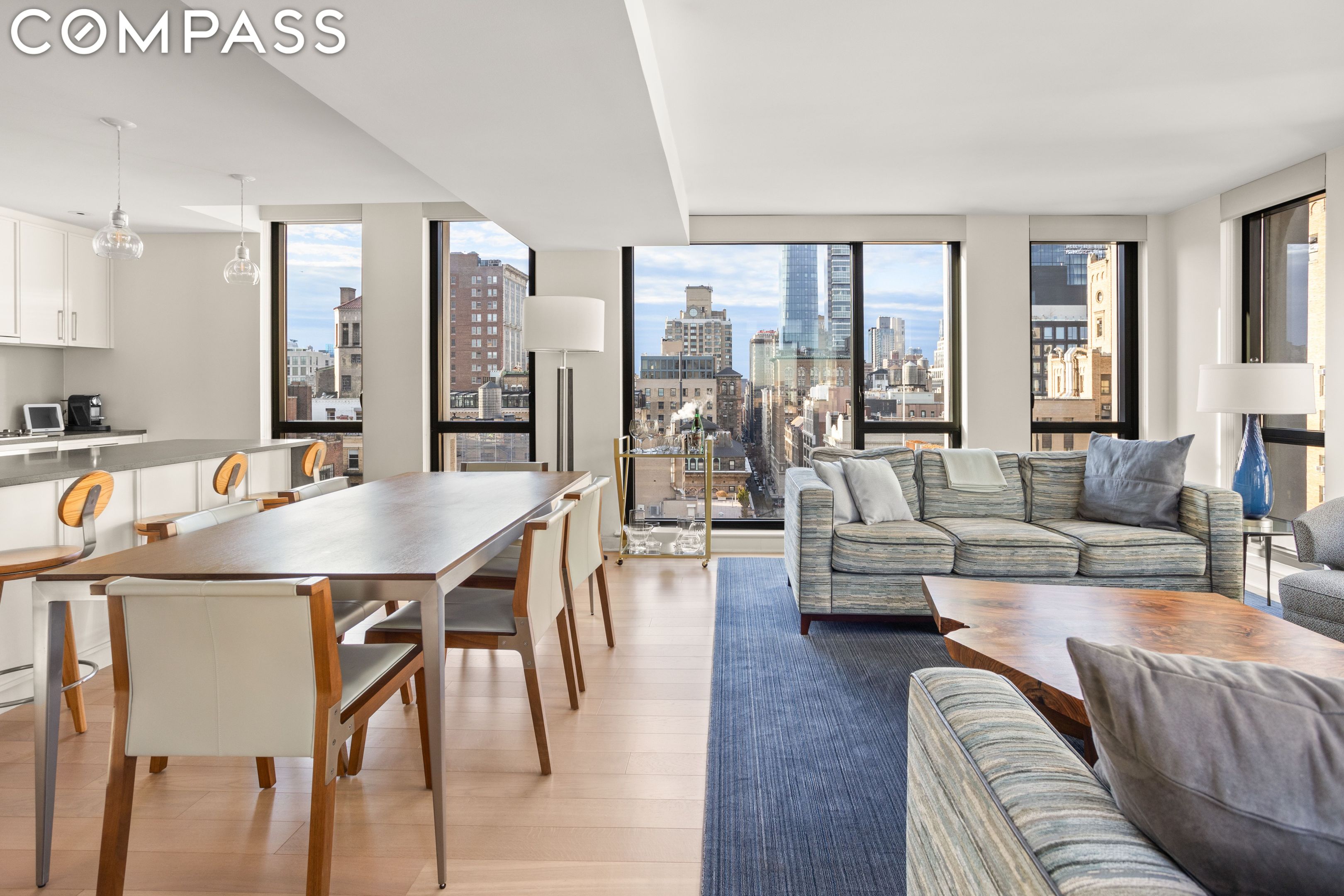 Open-plan living and dining area with floor-to-ceiling windows overlooking the city skyline.