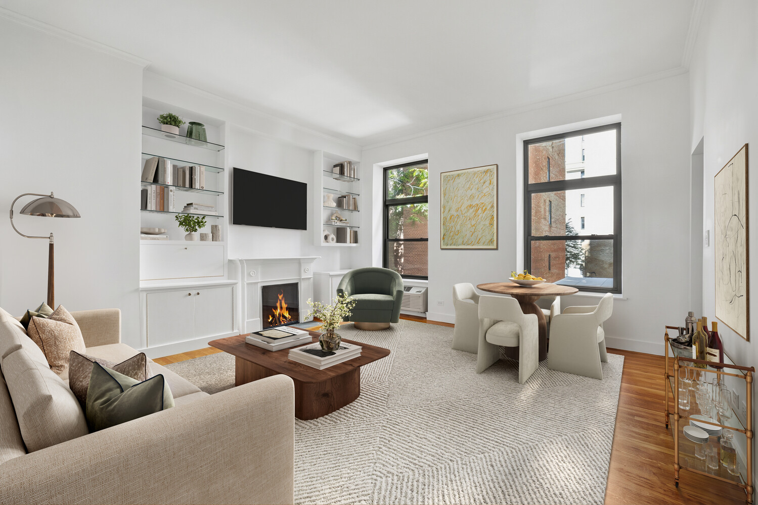 Living and dining room with a fireplace, built-in shelving, and large windows.