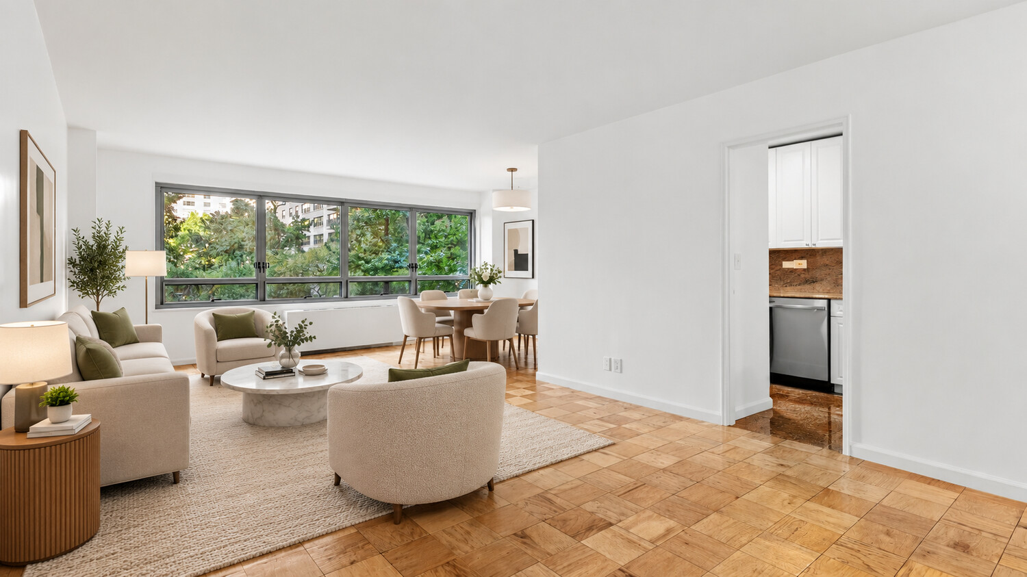 Staged living and dining room with parquet flooring and broad windows overlooking trees.