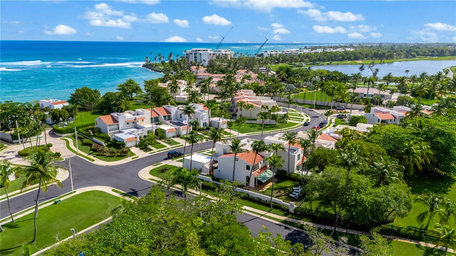 Aerial view of palm-lined homes near the ocean and lagoon in Dorado.