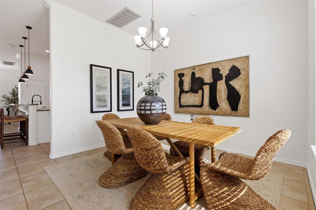 Dining room with a wooden table, woven wicker chairs, and large abstract wall art.