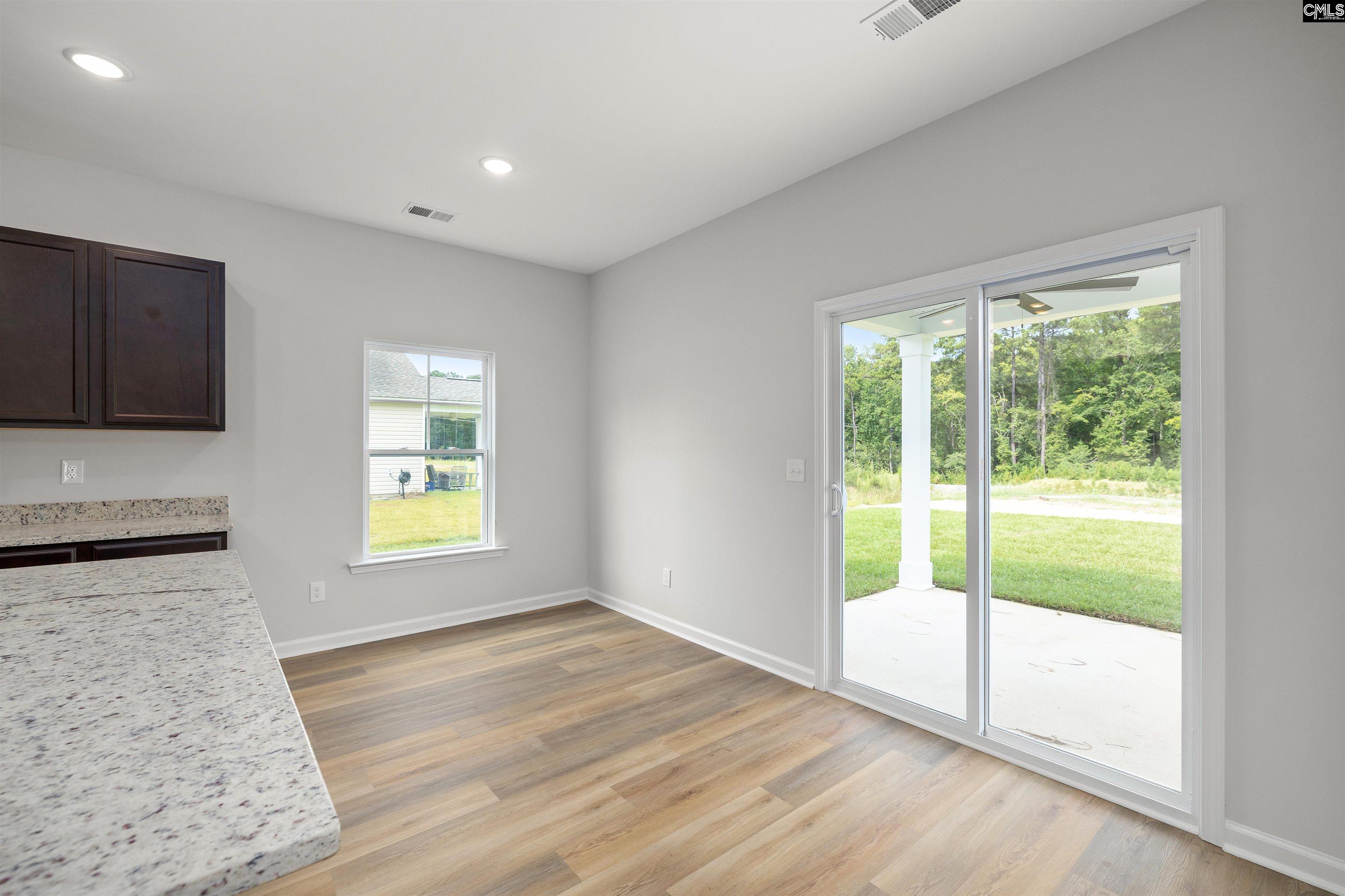 Unfurnished kitchen with a granite counter and sliding glass door to a covered patio.