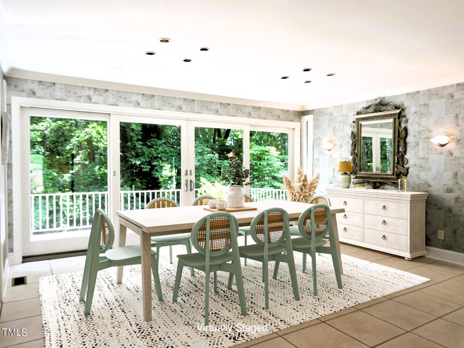 Virtually staged dining room with a long table, green chairs, and wide doors overlooking trees.