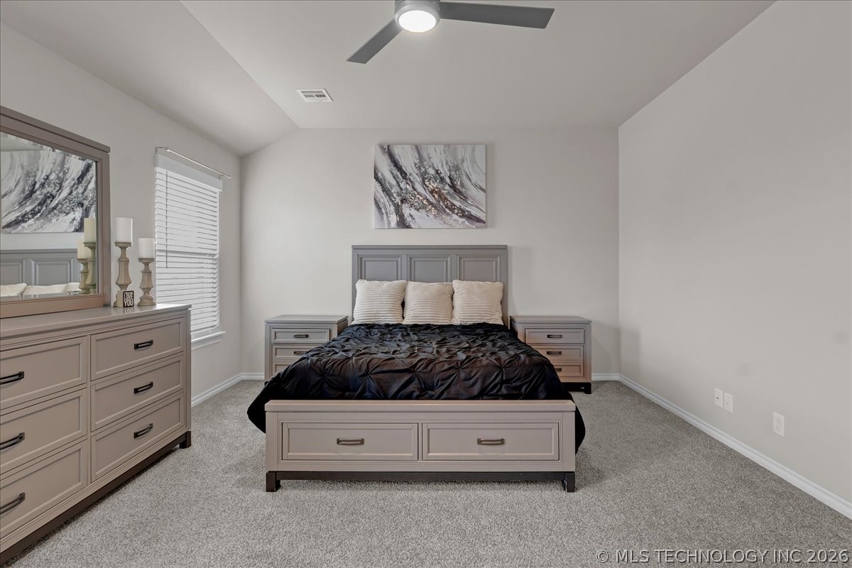 Bedroom with a gray bed, black bedding, matching furniture, and gray carpet.