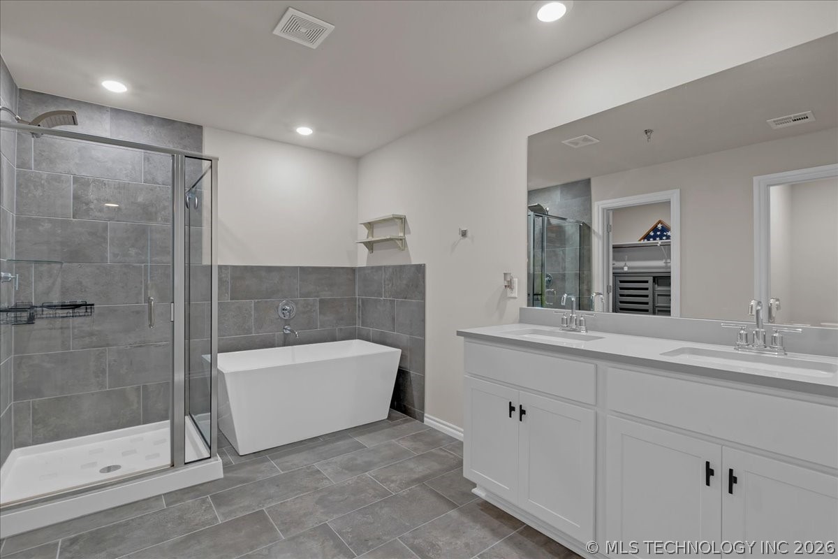 Bathroom with a glass shower, freestanding tub, and long double-sink vanity.