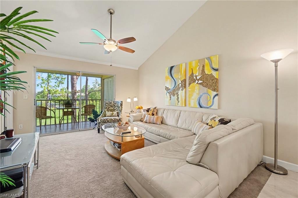 Living room with a cream sectional and sliding glass doors opening to a screened lanai.