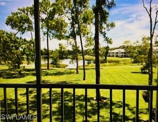 Balcony view across a tree-lined lawn to a lake and homes