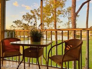 Furnished balcony with wicker chairs and a lake view through the railing.